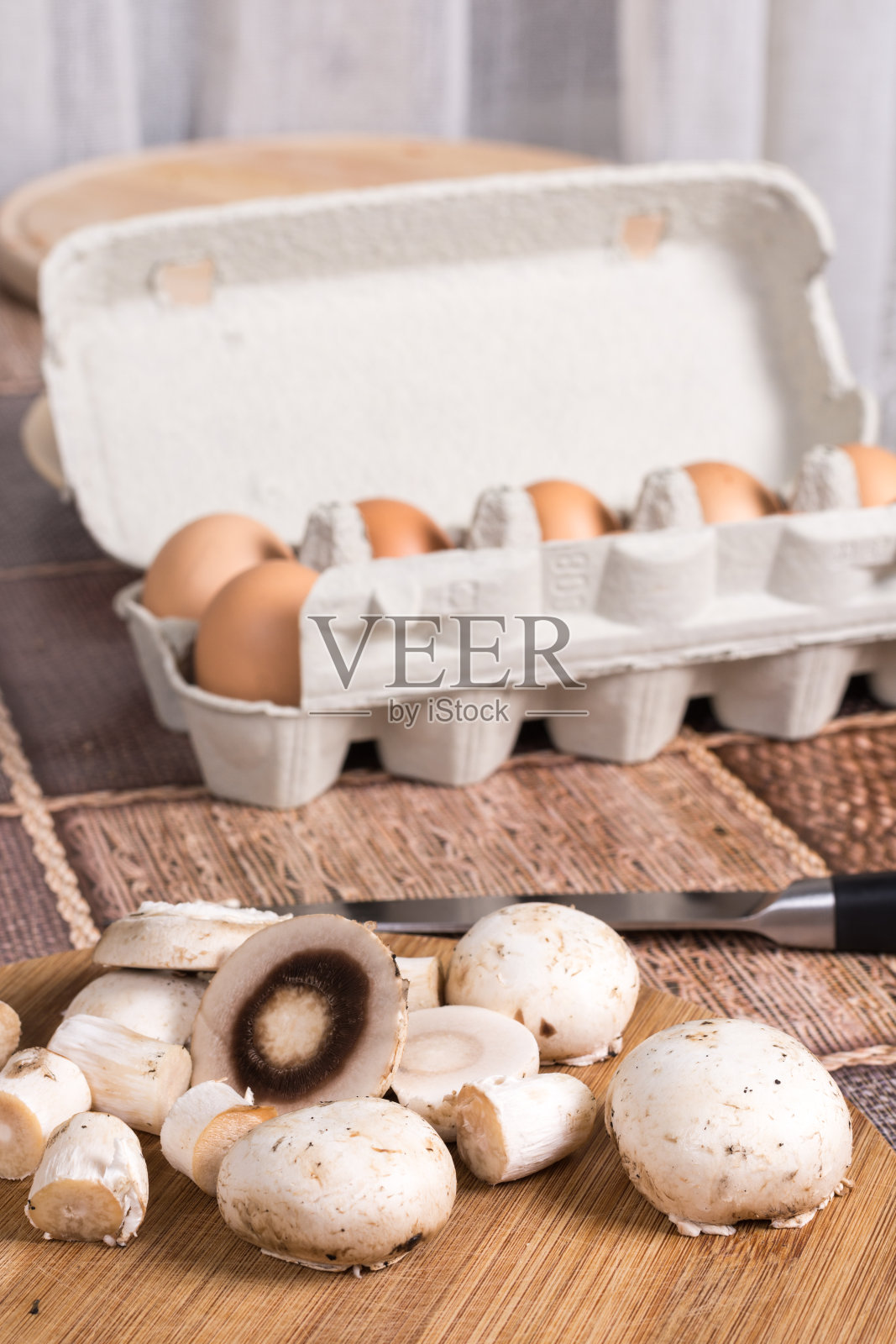 桌子上放着蘑菇片，背景是鸡蛋照片摄影图片