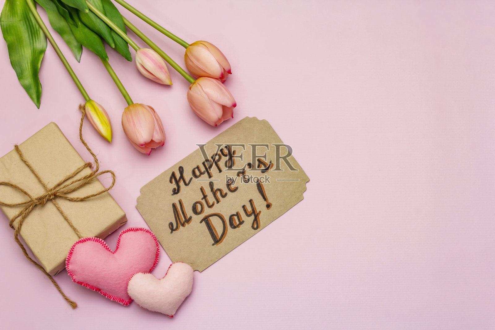 贺卡、墙纸、背景。母亲节快乐，情人节或婚礼快乐。温柔的粉色郁金香，手工制作的心形照片摄影图片