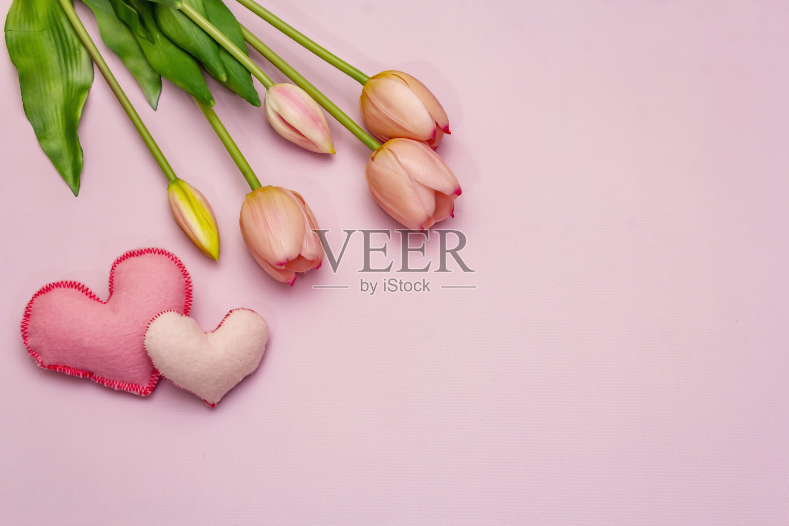 贺卡、墙纸、背景。母亲节快乐，情人节或婚礼快乐。温柔的粉色郁金香，手工制作的心形照片摄影图片