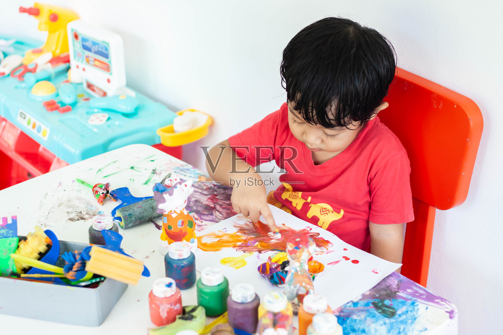 孩子们呆在家里玩水彩画。小男孩和水彩画。照片摄影图片