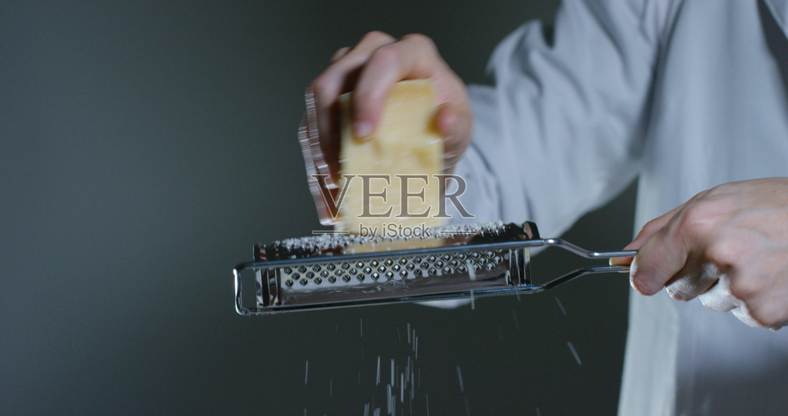 一个厨师磨碎的帕玛森奶酪，典型的意大利奶酪，在盘子里刚刚酿造。照片摄影图片