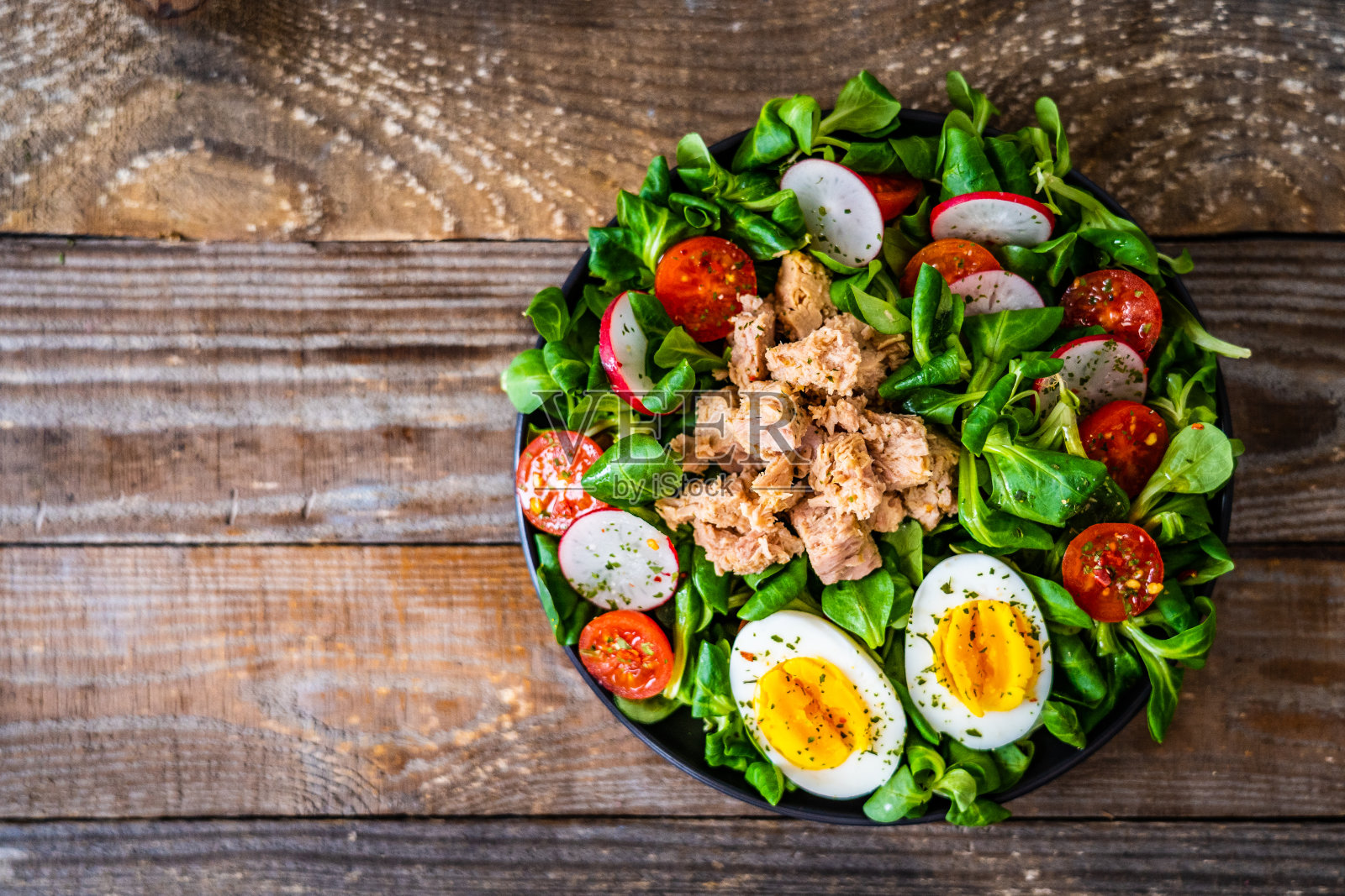 金枪鱼，煮鸡蛋和蔬菜沙拉在木制背景照片摄影图片
