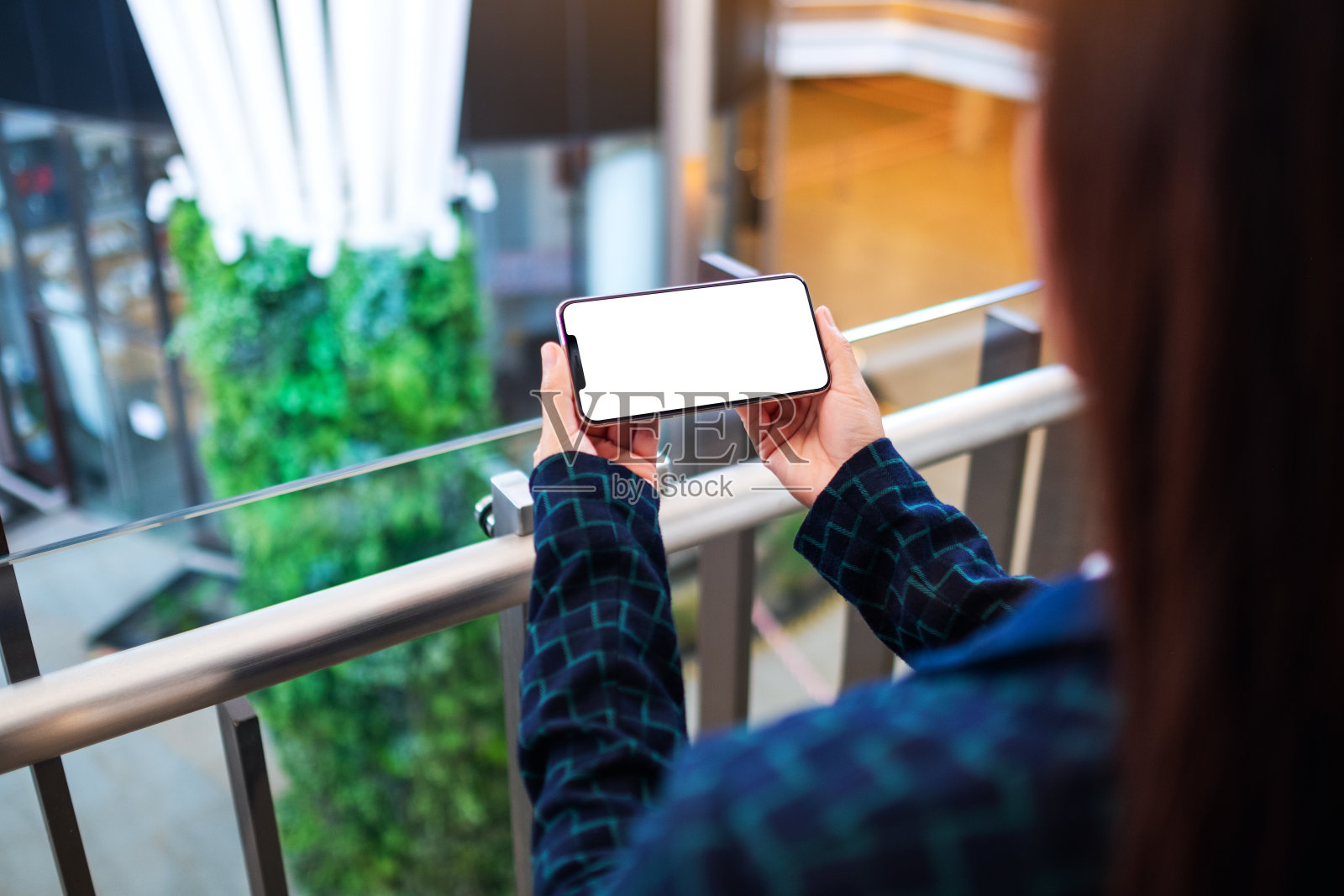 一名妇女在室内拿着白屏幕的手机照片摄影图片