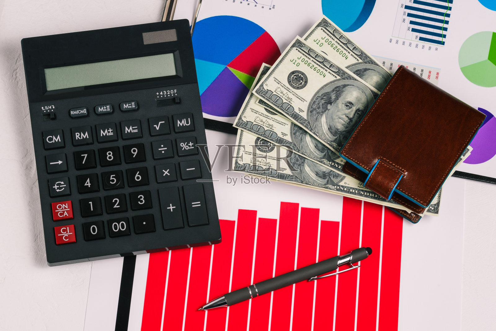 计算器，利润增长图和美元钱包。一个商人的办公桌。金融、投资和会计。照片摄影图片