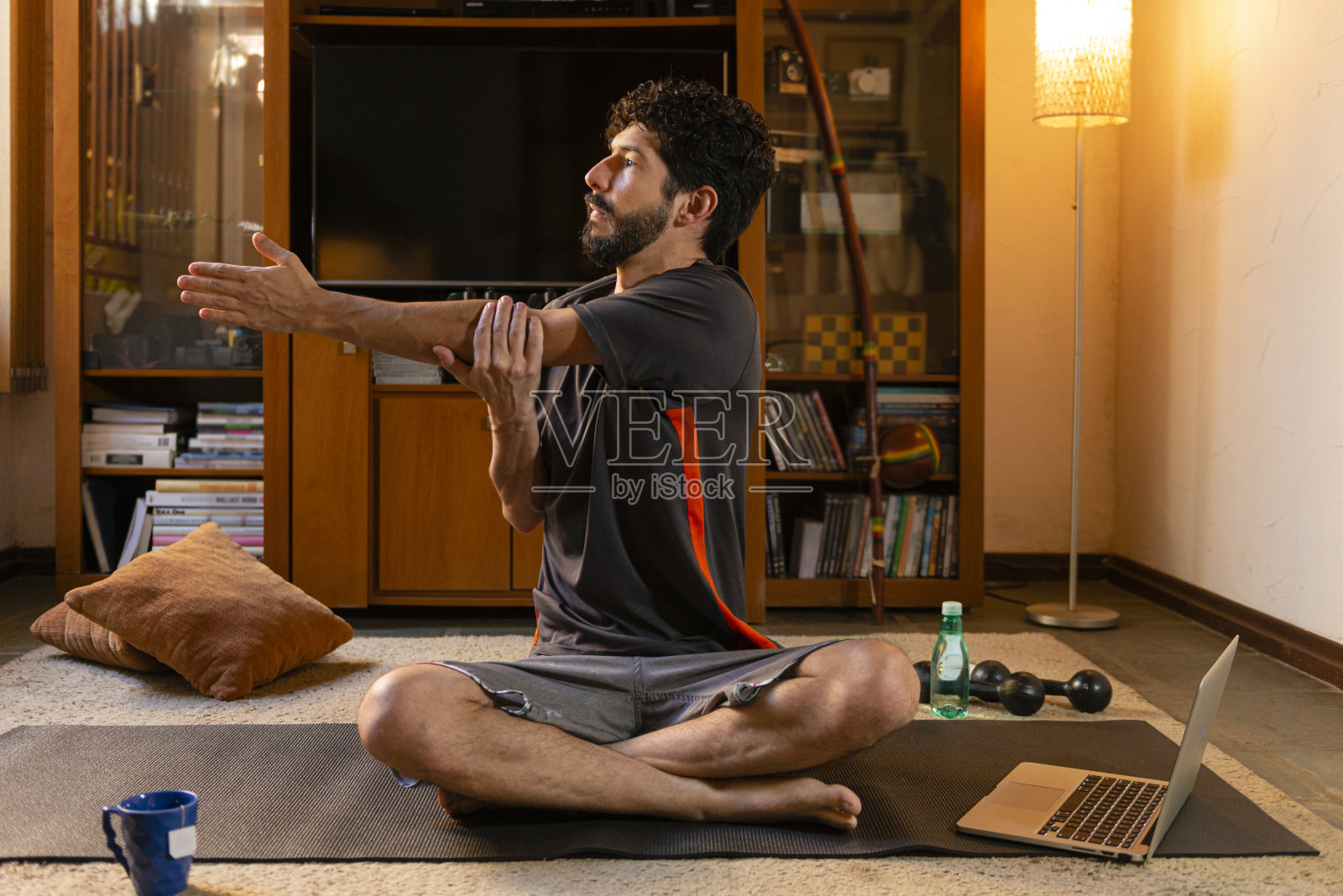 年轻人在家中进行伸展运动来进行身体活动练习照片摄影图片