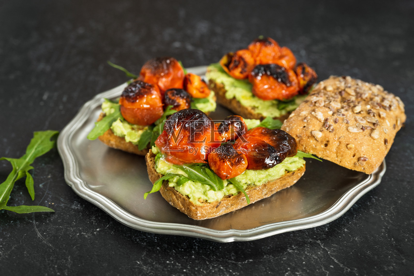 特写美味的素食鳄梨三明治与芝麻菜和烤番茄照片摄影图片