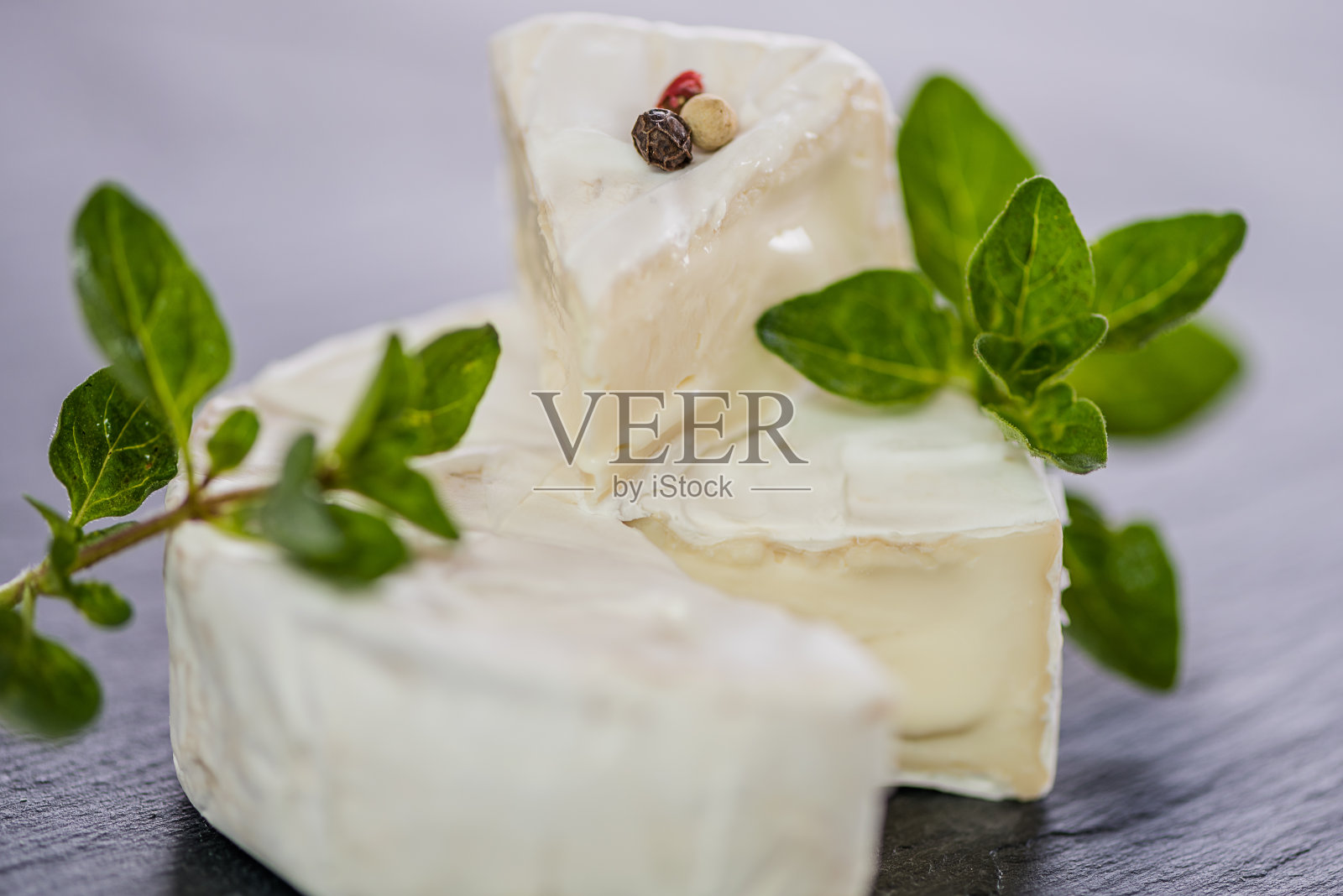 布里奶酪。卡蒙伯尔的奶酪。新鲜的布里干酪和一片放在木板上，加上坚果，蜂蜜和树叶。意大利、法国奶酪。照片摄影图片