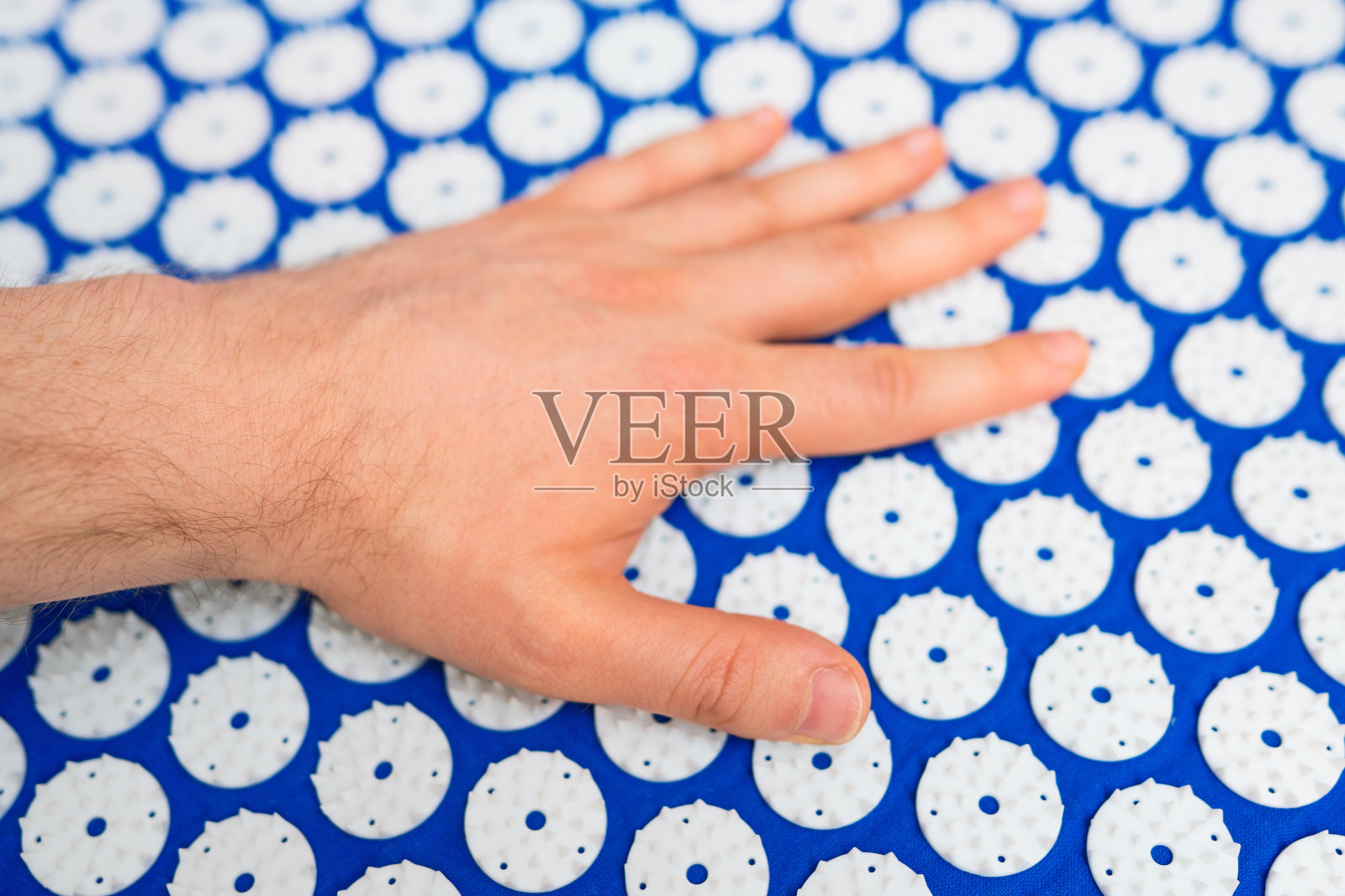 男人在针灸地毯上。选择中国医学。照片摄影图片