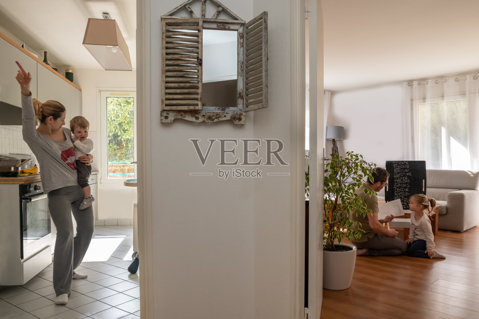 母亲在厨房跳舞，父亲和女儿一起做功课照片摄影图片