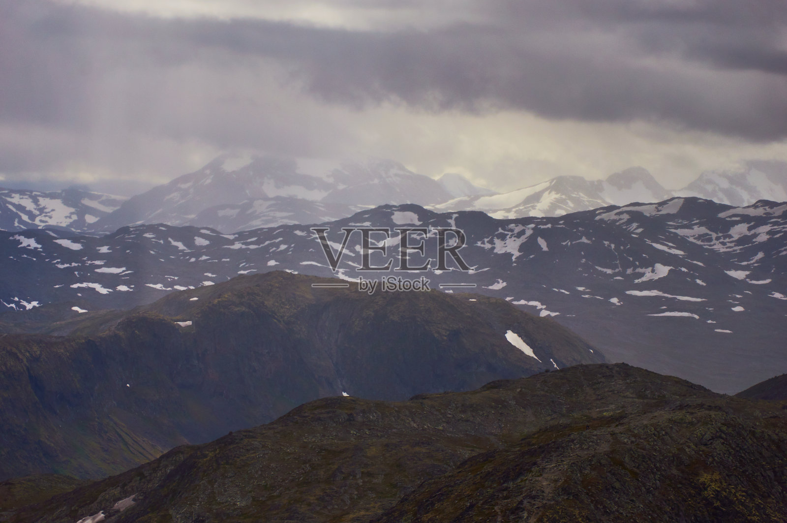 美丽的山脉鸟瞰图与雾反对暴风雨的天空在挪威Jotunheimen山脉的心脏。照片摄影图片