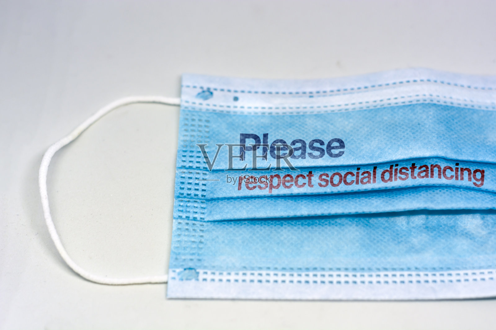 蓝色外科口罩，用来保持社交距离，不要太近。新冠肺炎大流行和社交距离，以防止病毒传播照片摄影图片