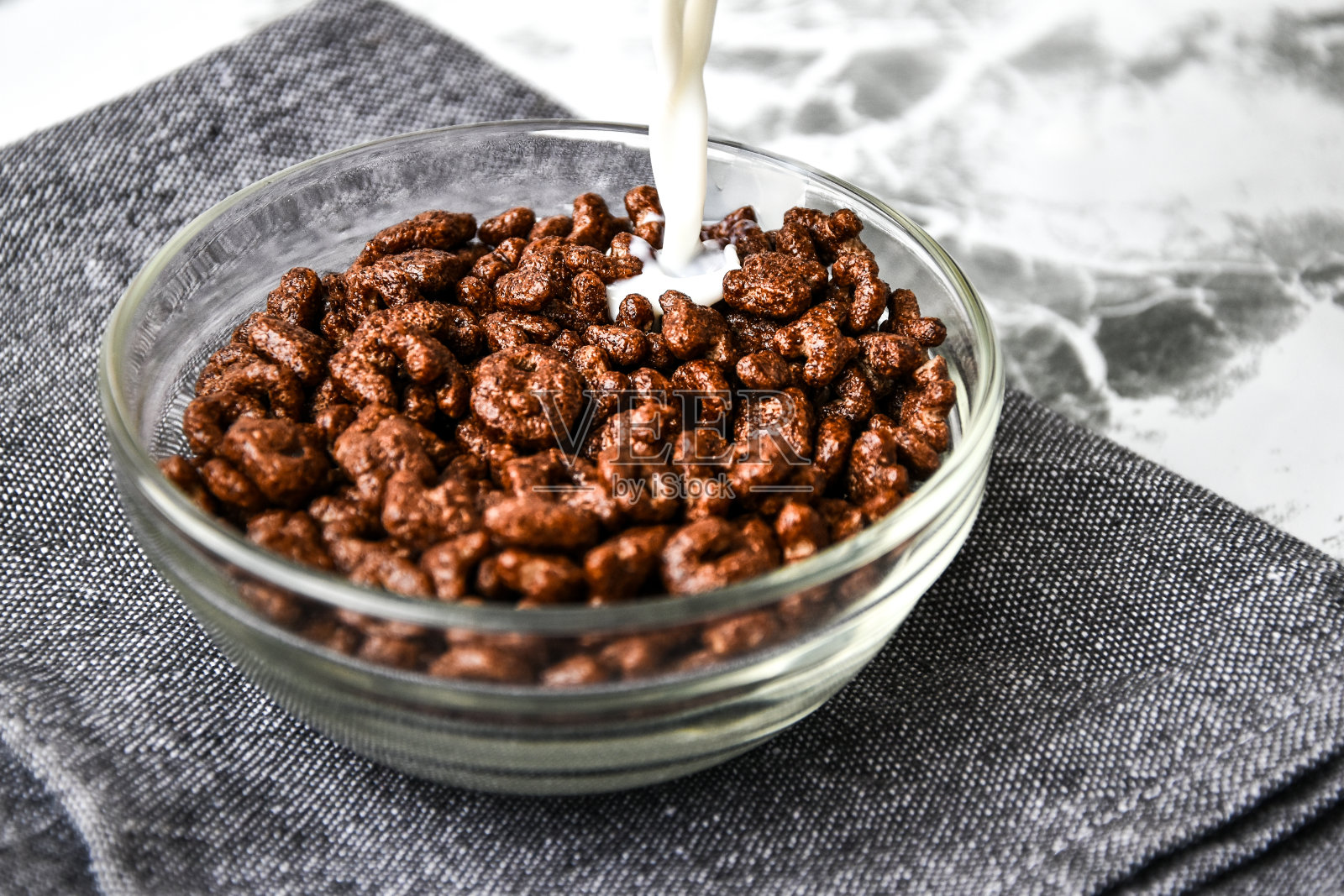 牛奶倒进碗里，早餐是字母形状的巧克力玉米片，回到学校照片摄影图片