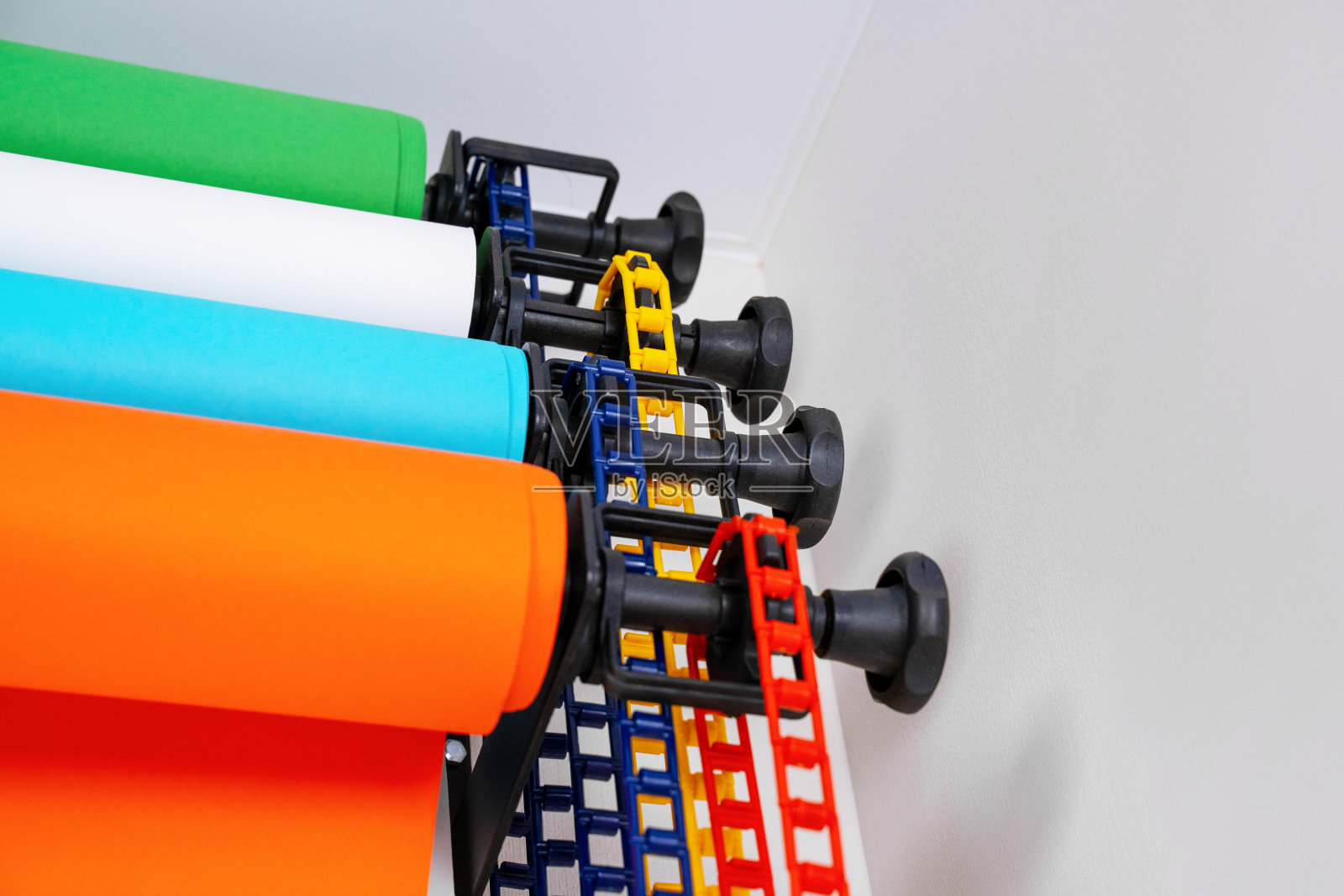 特殊摄影背景系统配墙安装，四卷彩色(绿、白、蓝、橙)。在室内,工作室设备。照片摄影图片