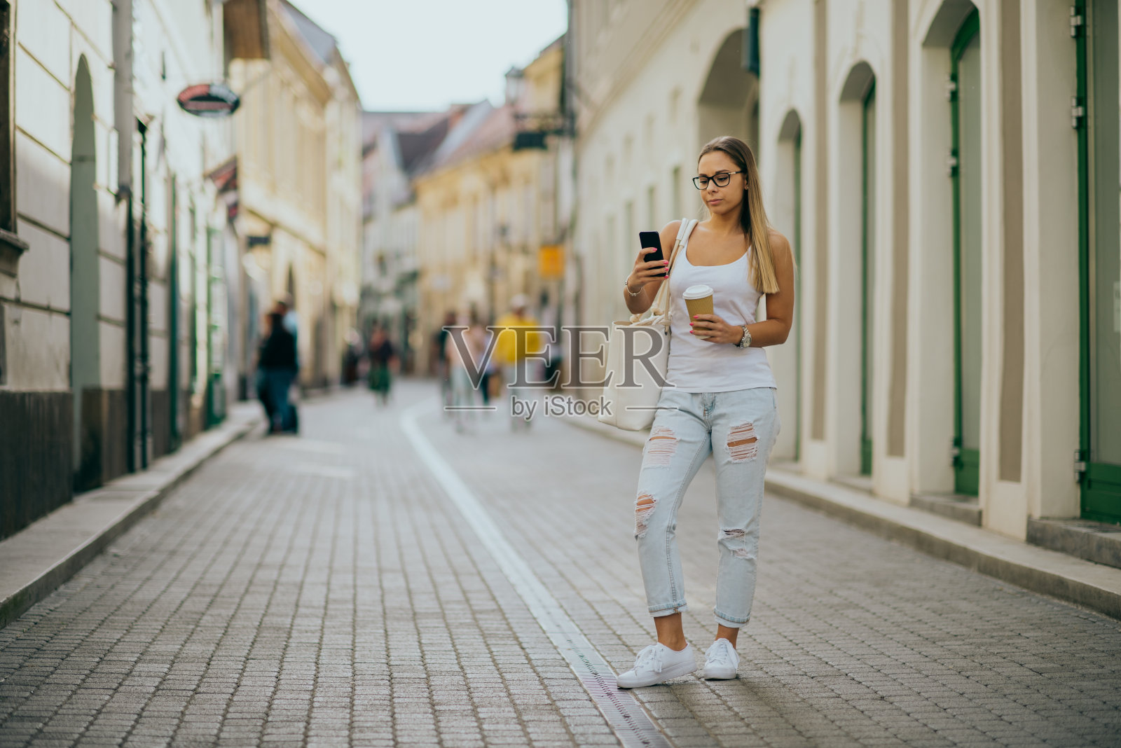 在城市里使用智能手机的女人照片摄影图片