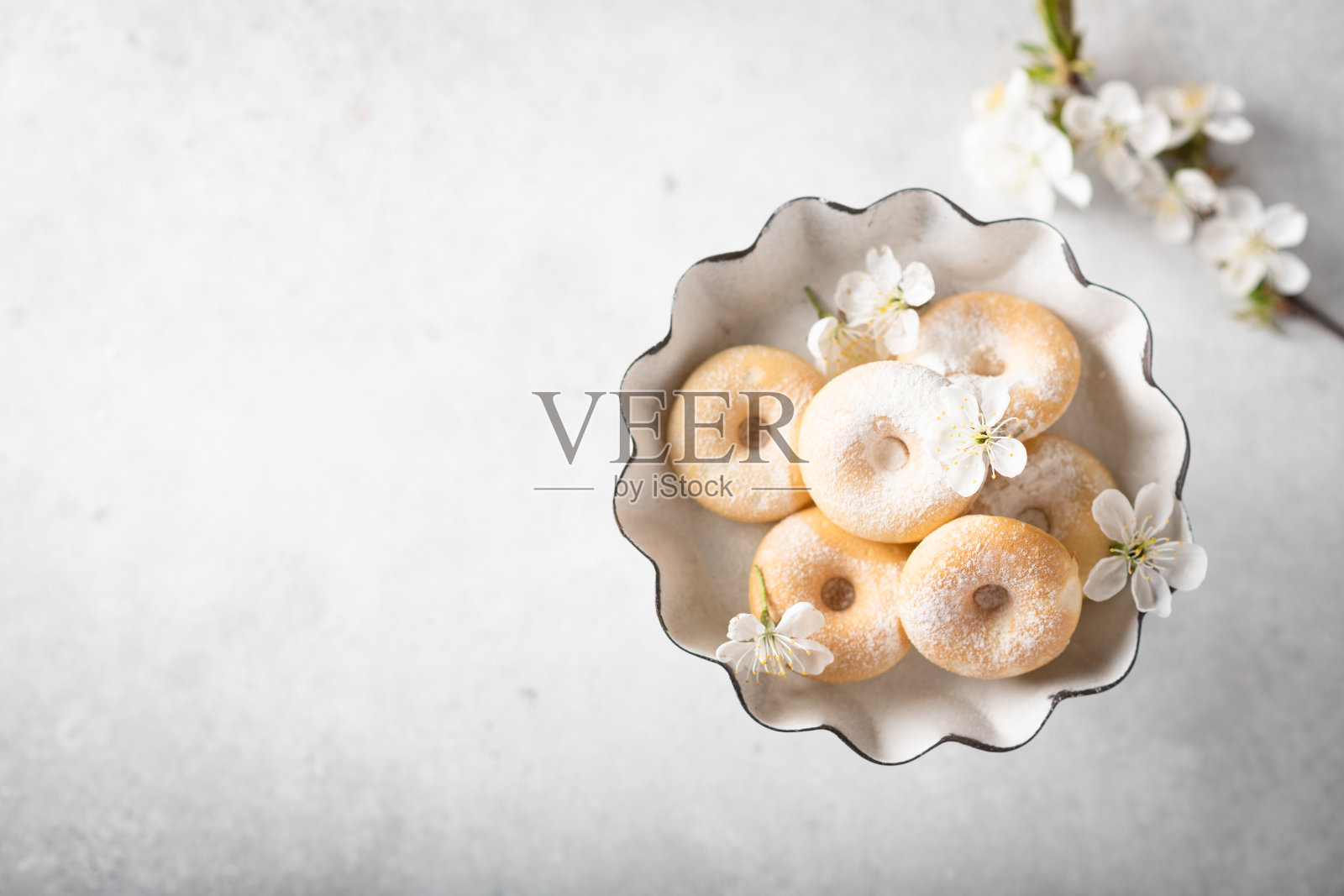 甜甜圈放在一个有樱花的古董花瓶里照片摄影图片