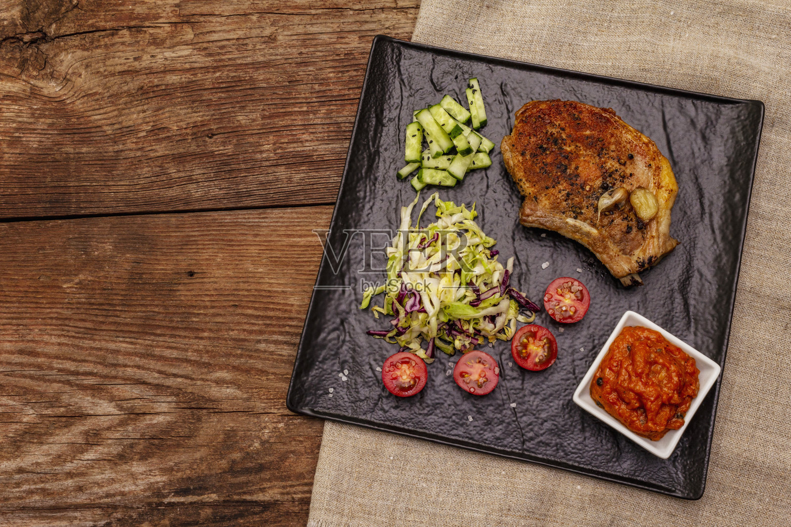 烤猪肉牛排。凉菜沙拉，番茄酱，新鲜蔬菜照片摄影图片