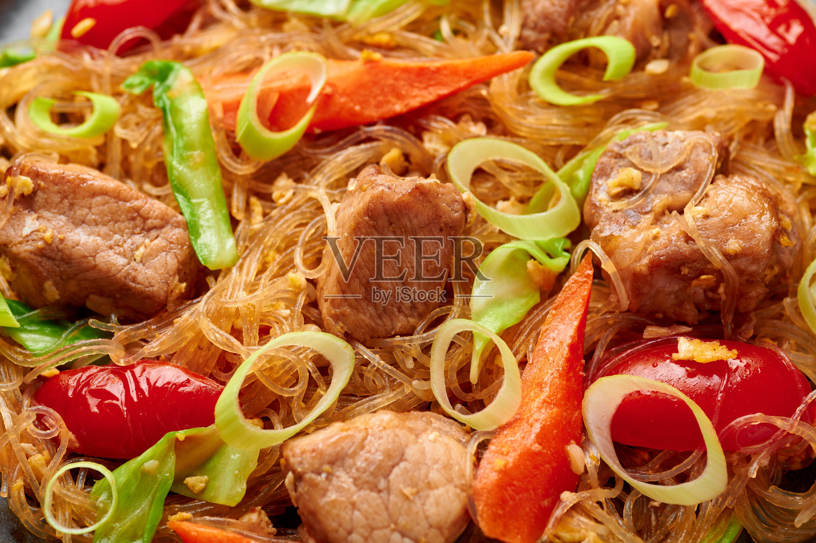 炒面或泰式猪肉玻璃面炒合纹理。Pad Woon Sen是一道由玻璃豆面、肉、西红柿、胡萝卜、鸡蛋和酱料制成的泰国美食。泰国菜。照片摄影图片