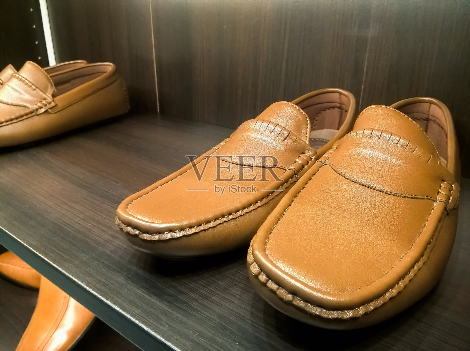 男皮鞋在商店的架子上。照片摄影图片