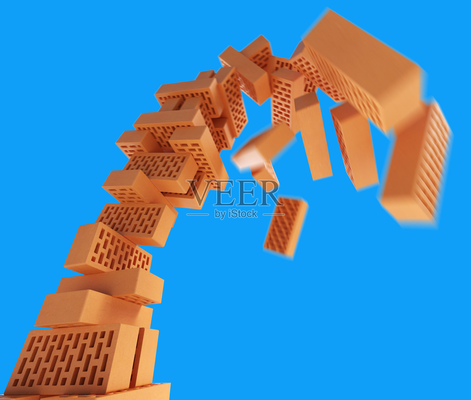 蓝色背景上的砖块塔的倒塌。照片摄影图片