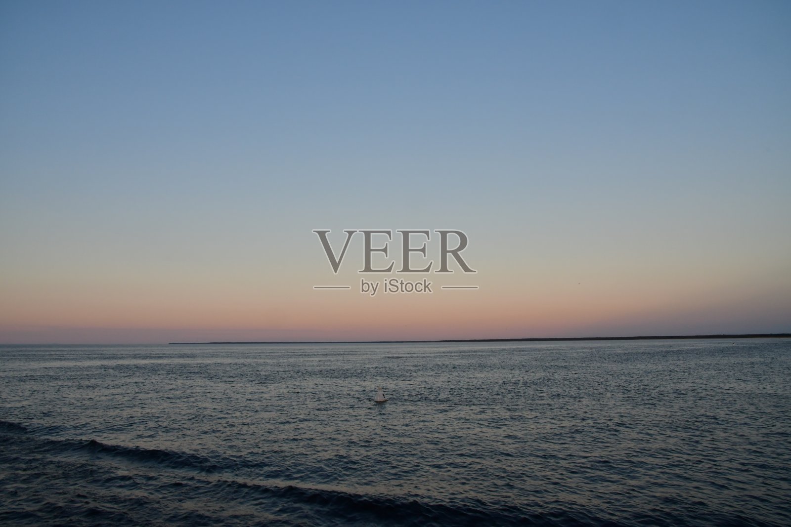 日落时分的拉多加湖，水面和壮观的天空之间的地平线上有一条狭长的陆地照片摄影图片