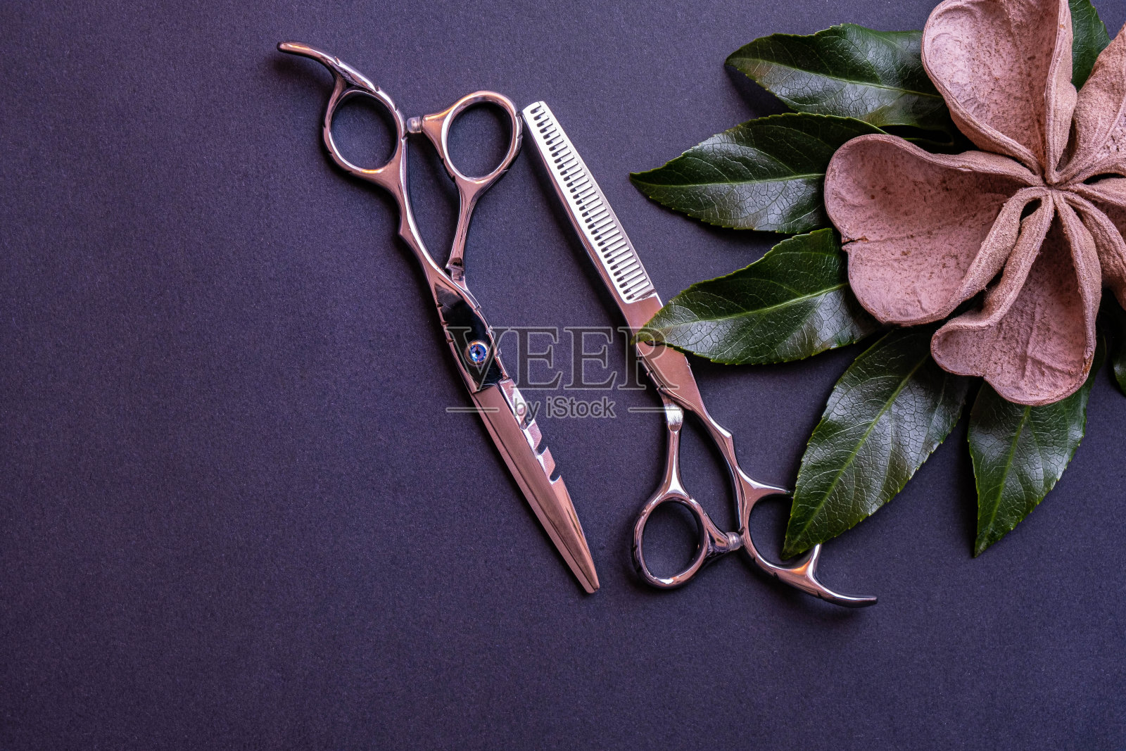 一把由木头制成的理发师用剪刀和装饰品放在有纹理的背景上照片摄影图片