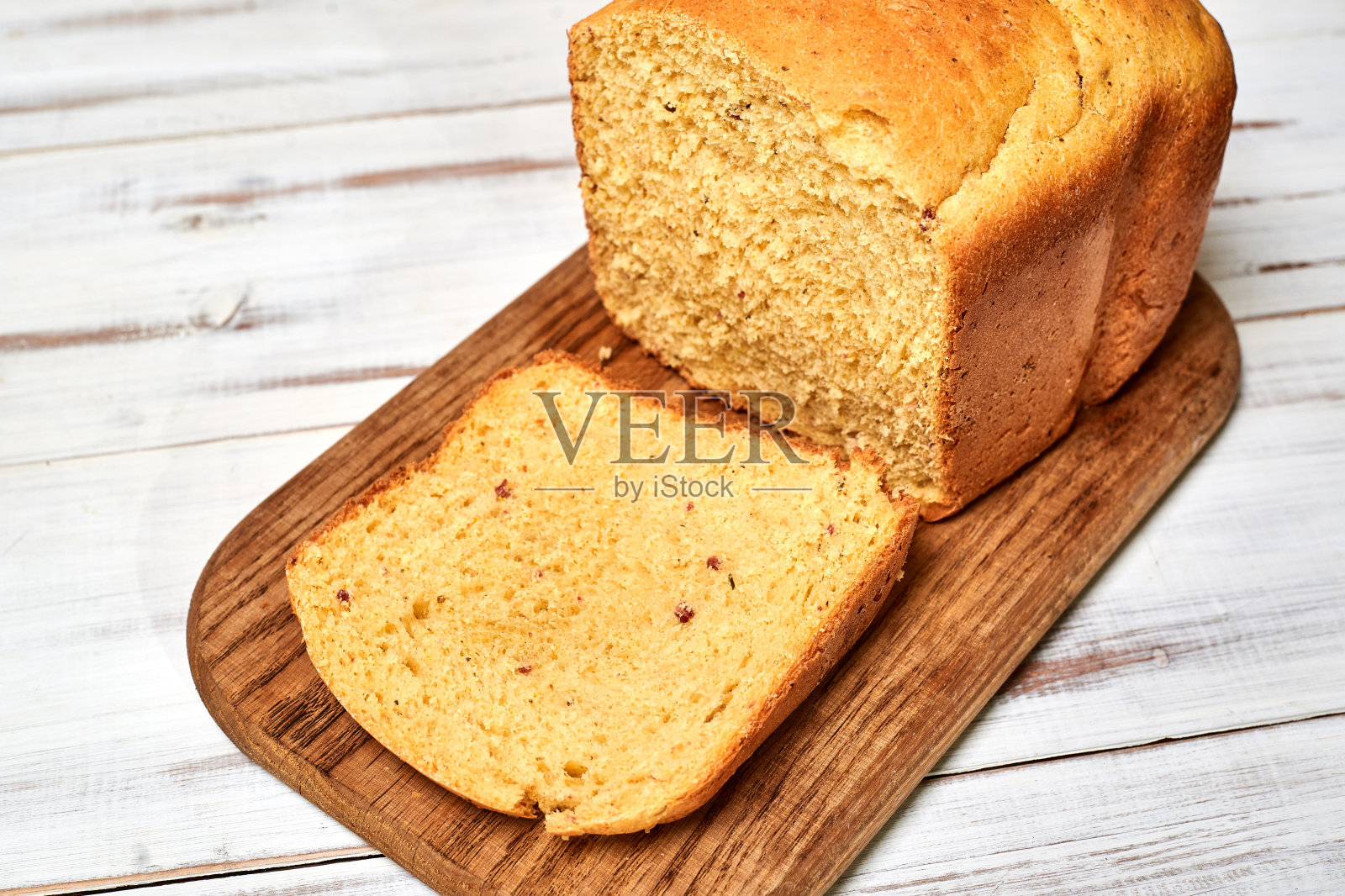 白木背景上的一块自制面包。照片摄影图片