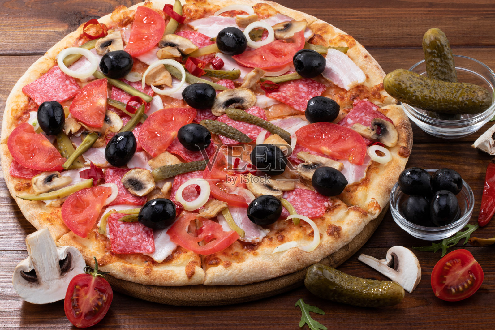 披萨配意大利辣香肠和橄榄，背景是木制的照片摄影图片