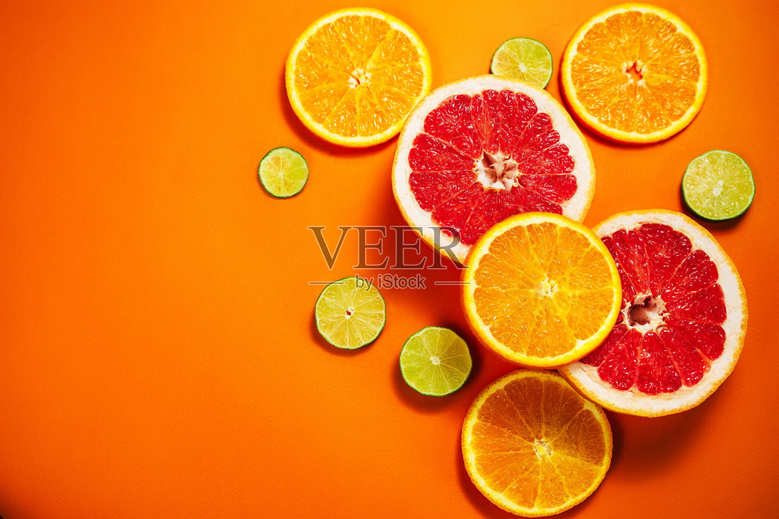 橙色背景上点缀着新鲜的柑橘片。照片摄影图片