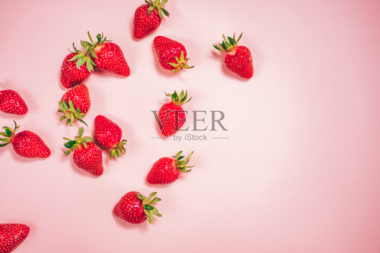 淡粉色背景上有新鲜草莓。照片摄影图片