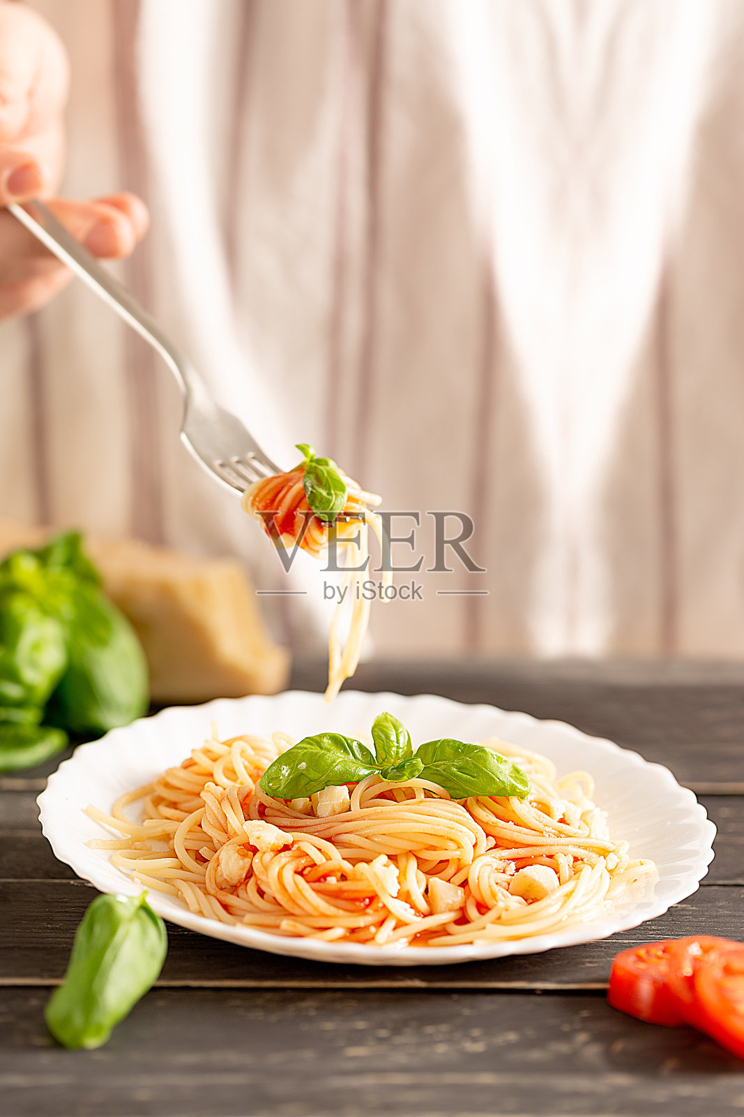 美味可口的经典意大利意大利面，配上番茄酱，帕尔马干酪和新鲜的罗勒照片摄影图片