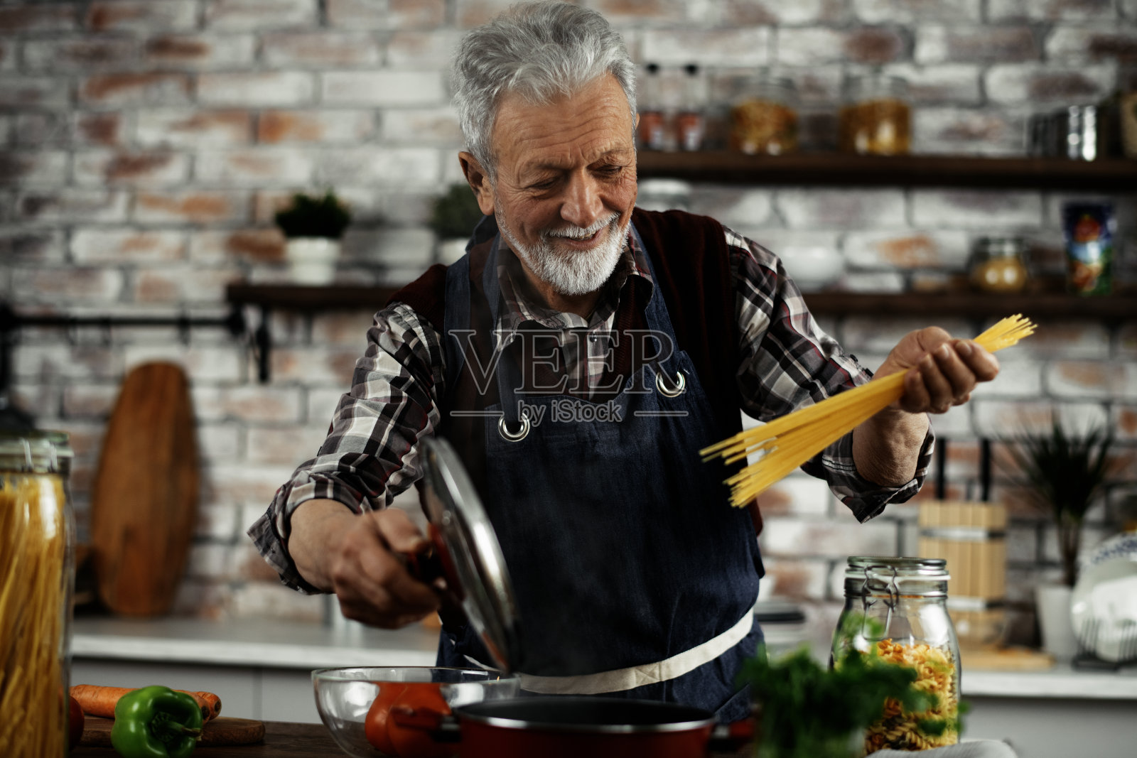 老人在家里准备美味的食物。照片摄影图片