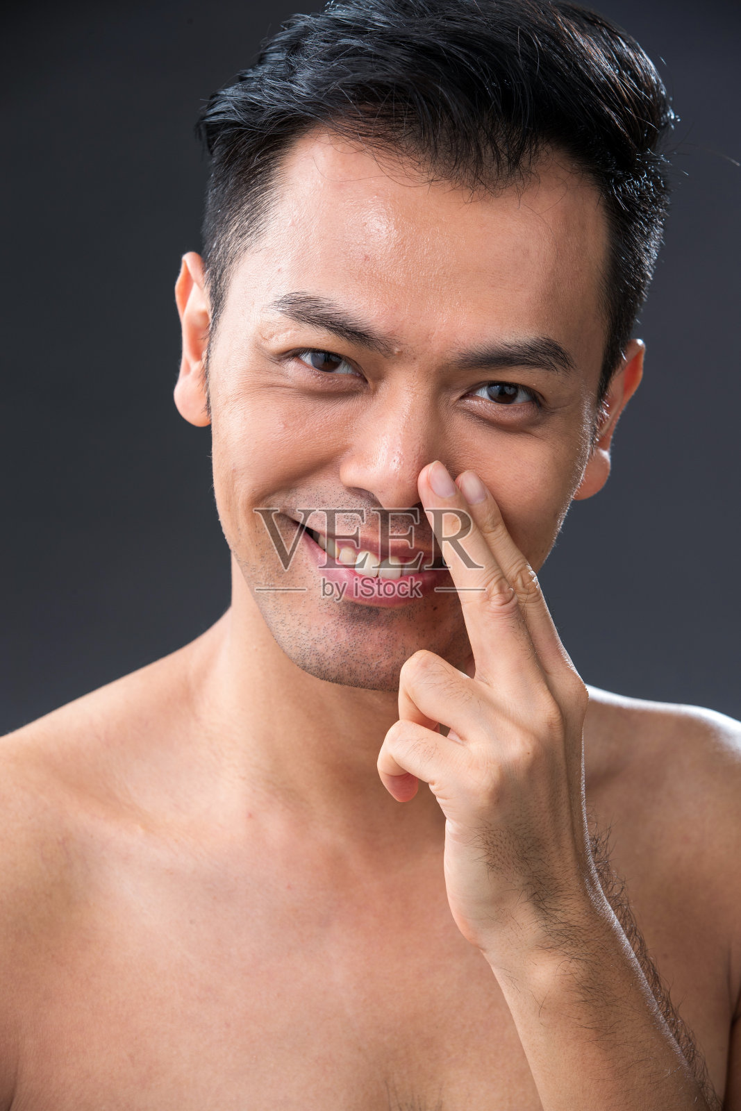 用手指触摸鼻子的中年男子照片摄影图片