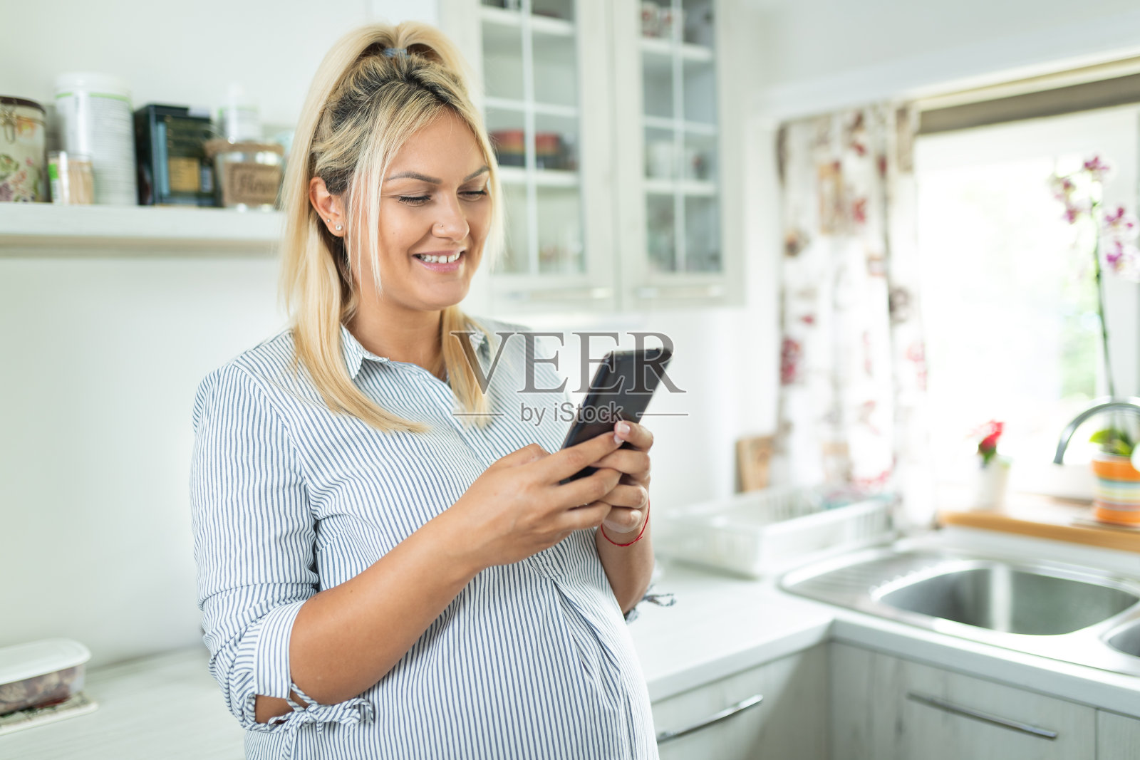 年轻孕妇使用手机照片摄影图片