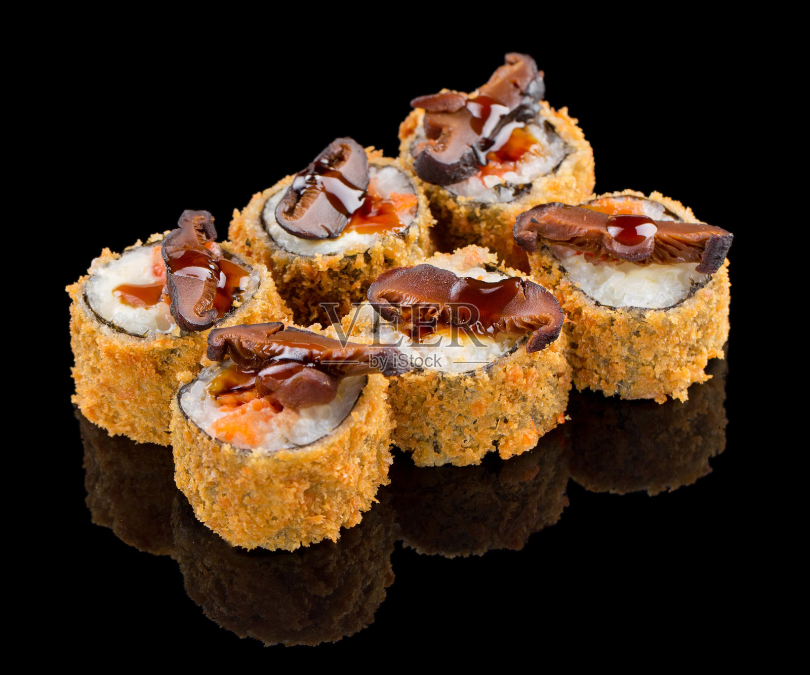 热炸寿司卷，三文鱼，酱汁和蘑菇在上面孤立的黑色背景反射照片摄影图片