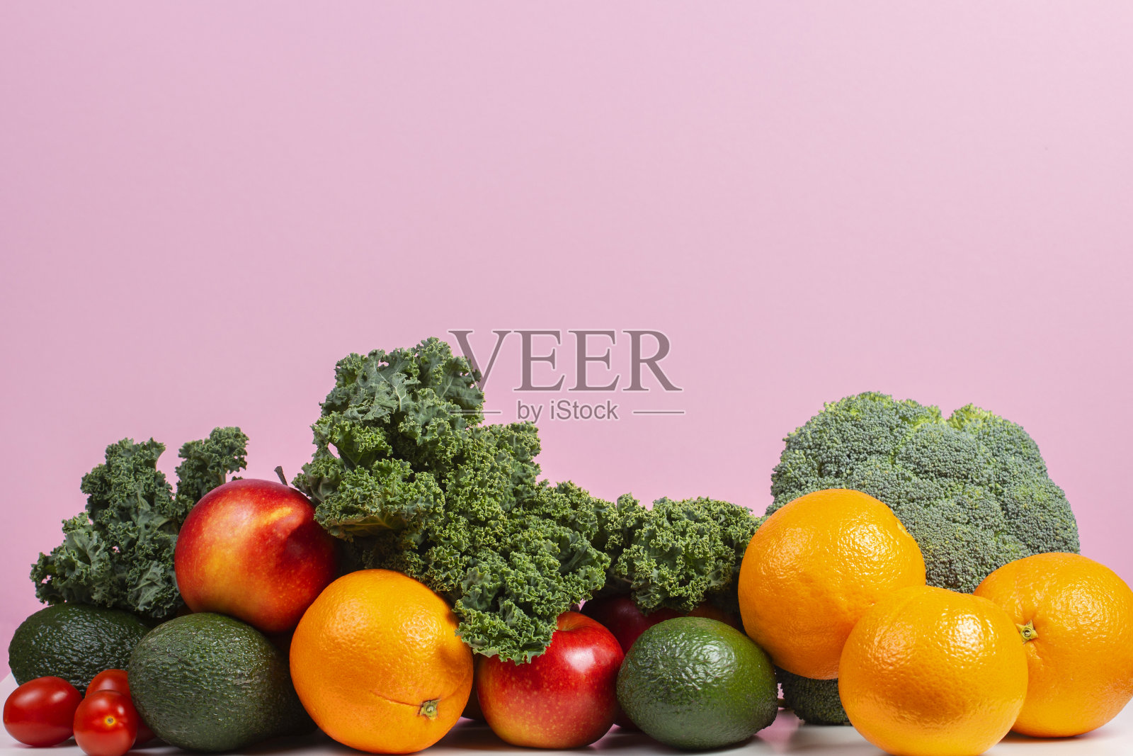 新鲜的生蔬菜和水果。健康的饮食背景包括橙子，苹果，羽衣甘蓝，花椰菜，橙子，番茄，鳄梨照片摄影图片