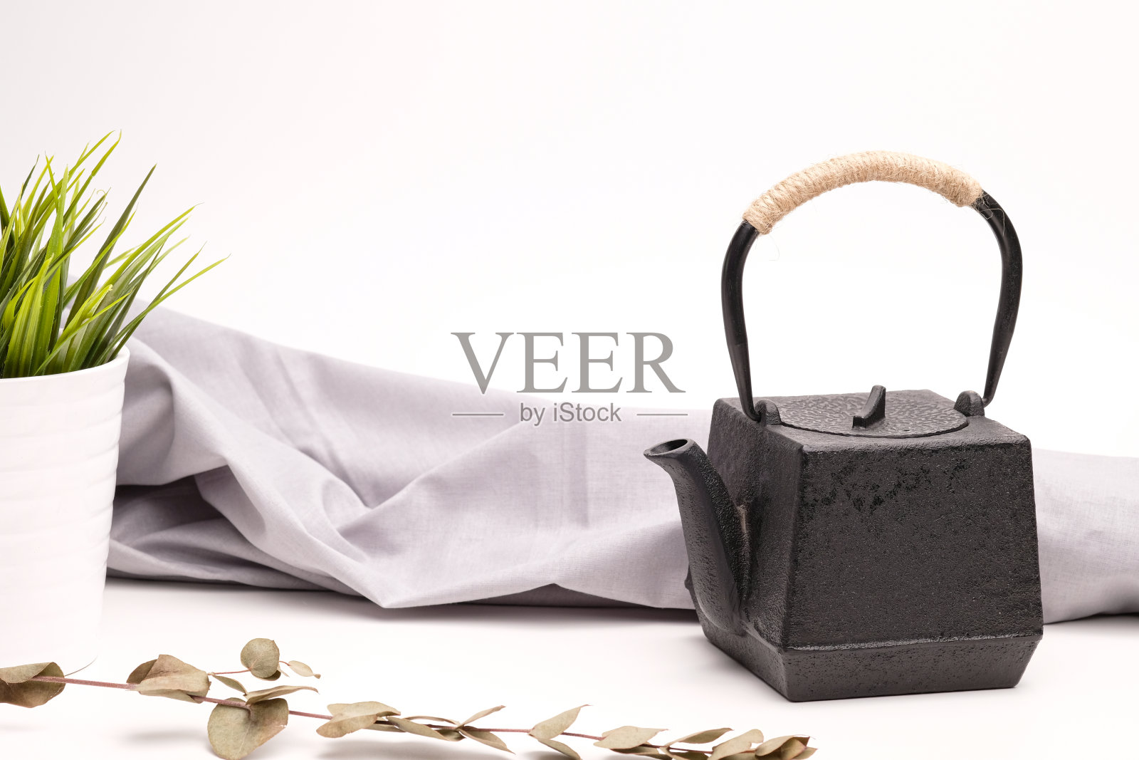 白色背景上的黑色金属铸铁茶壶。照片摄影图片