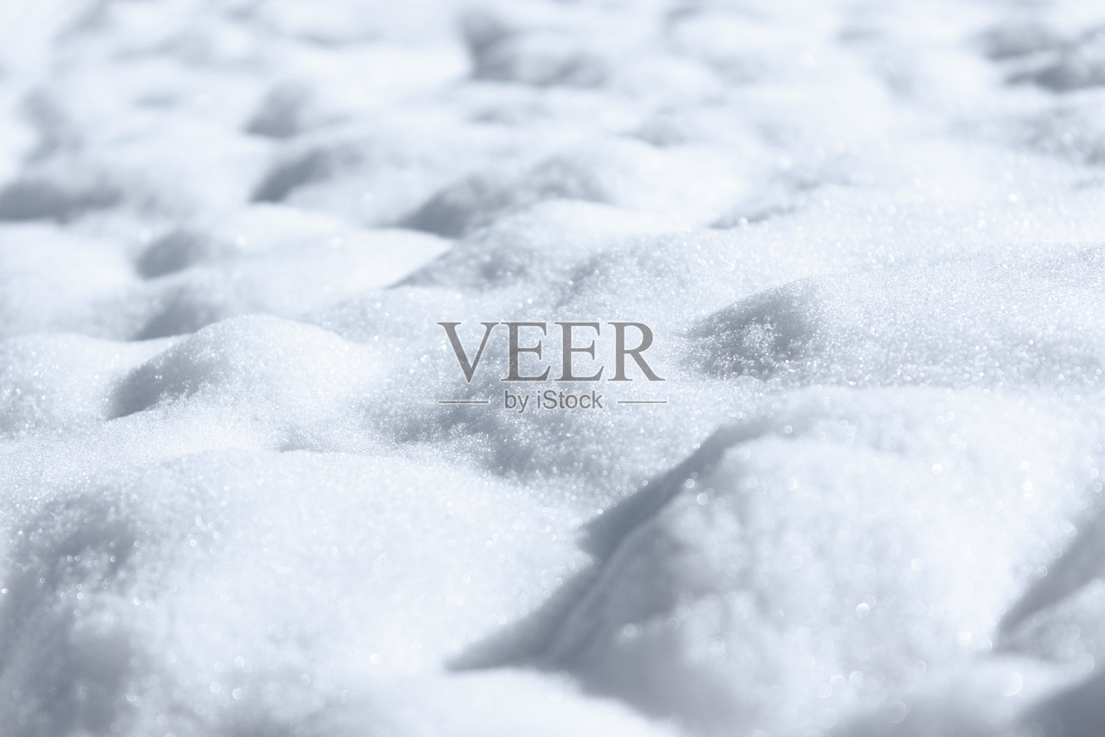 纯粹的雪。凹凸不平的雪堆背景与透视和近距离蓝色色调。照片摄影图片