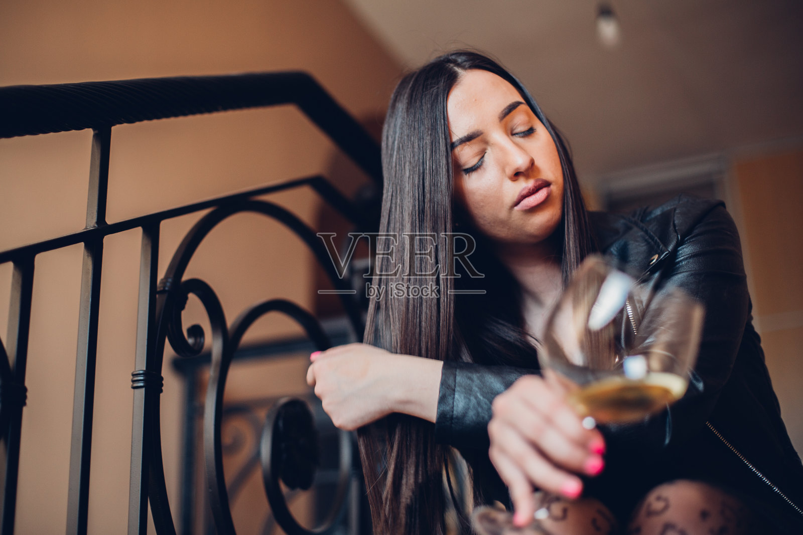 年轻的女孩，在阳台上喝着红酒照片摄影图片