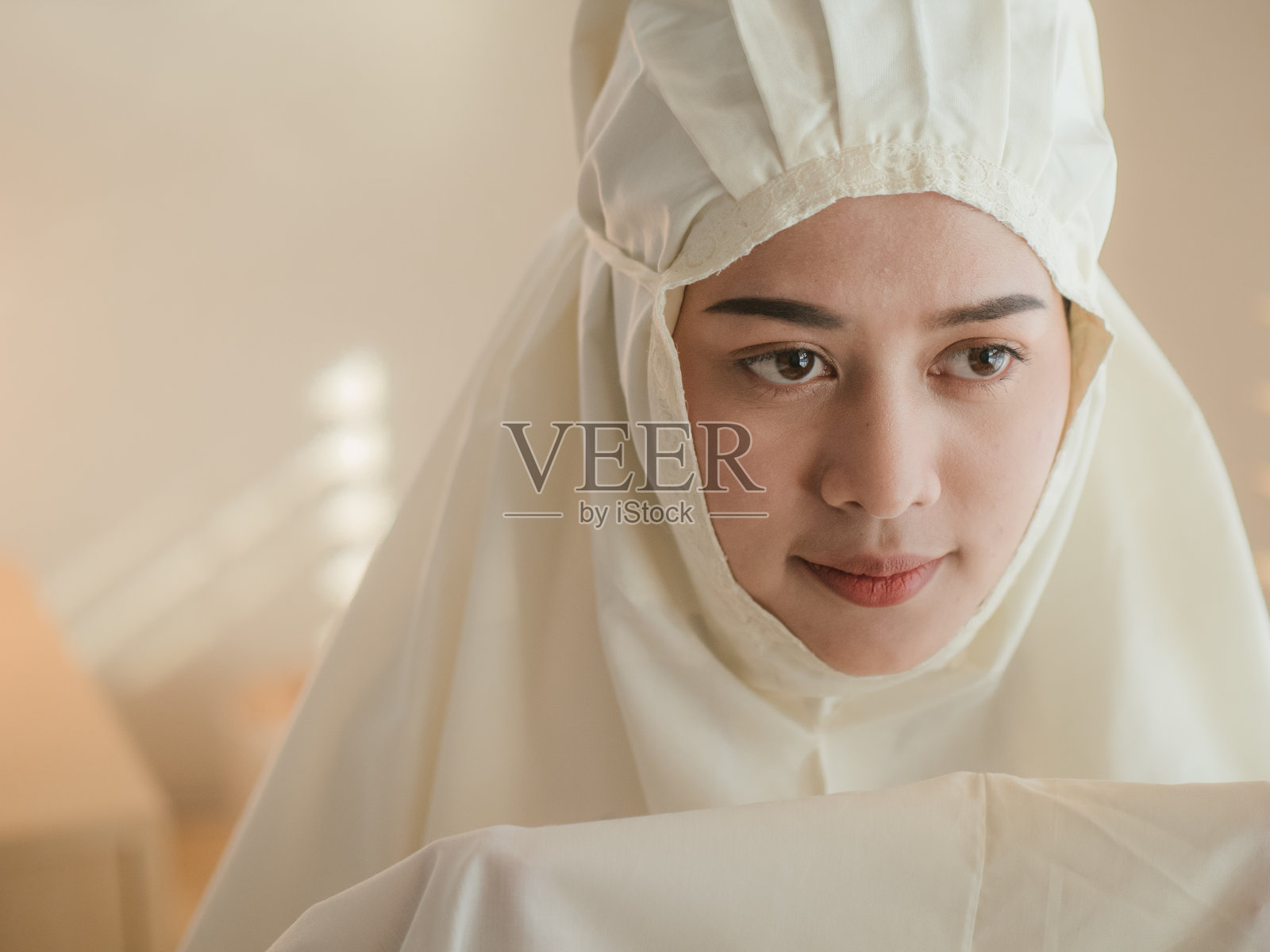 在窗户附近祈祷的伊斯兰妇女照片摄影图片