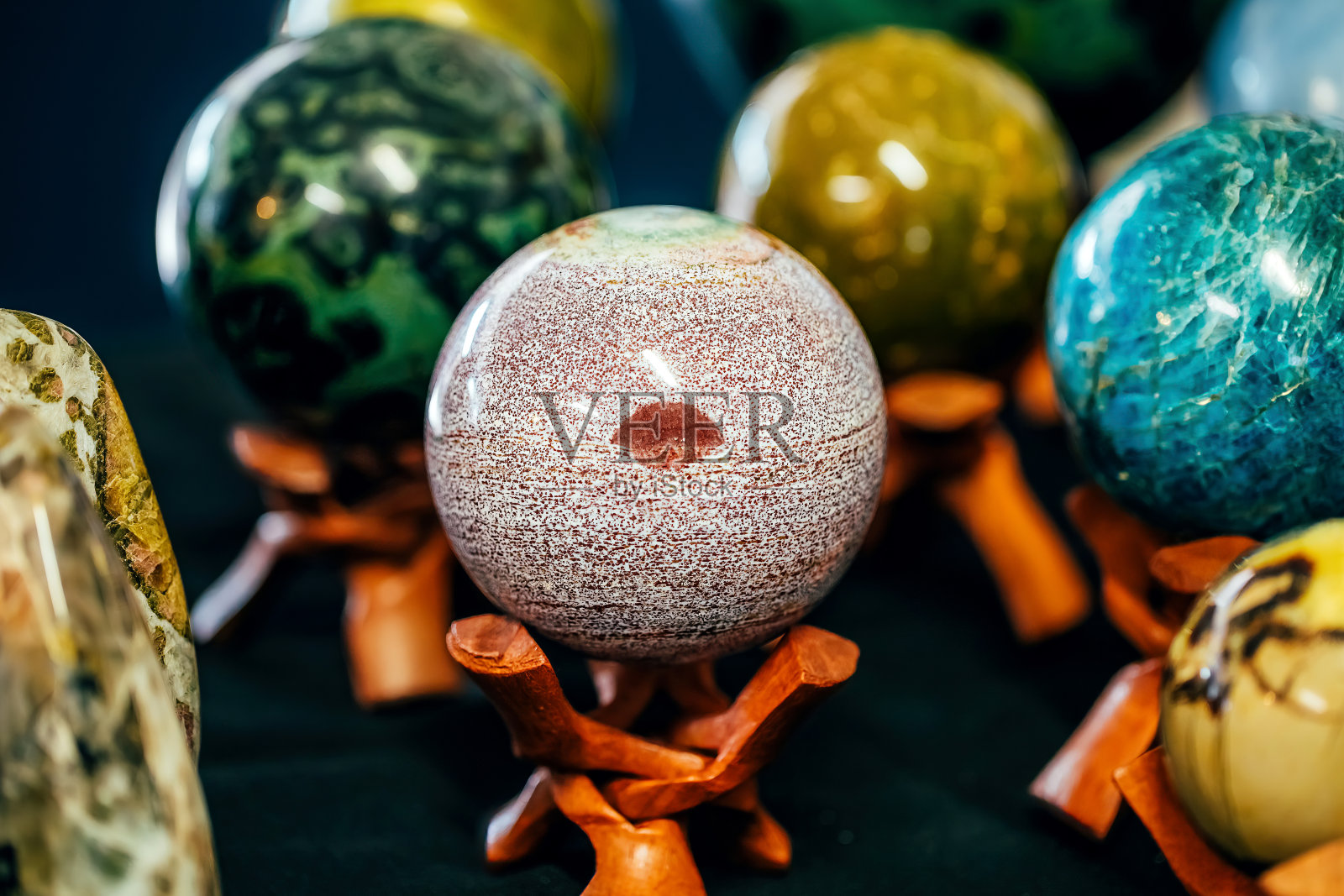 在架子上有一个像嘴唇一样的标记的球形石头。各种宝石、矿物、宝石照片摄影图片