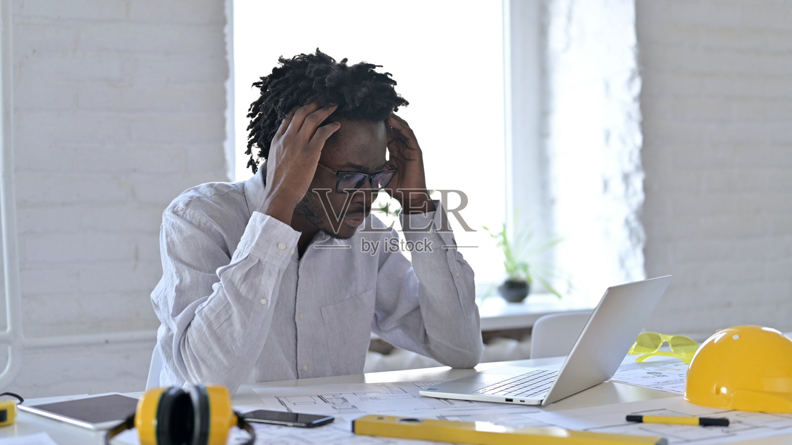 震惊的非洲工程师在用笔记本电脑照片摄影图片