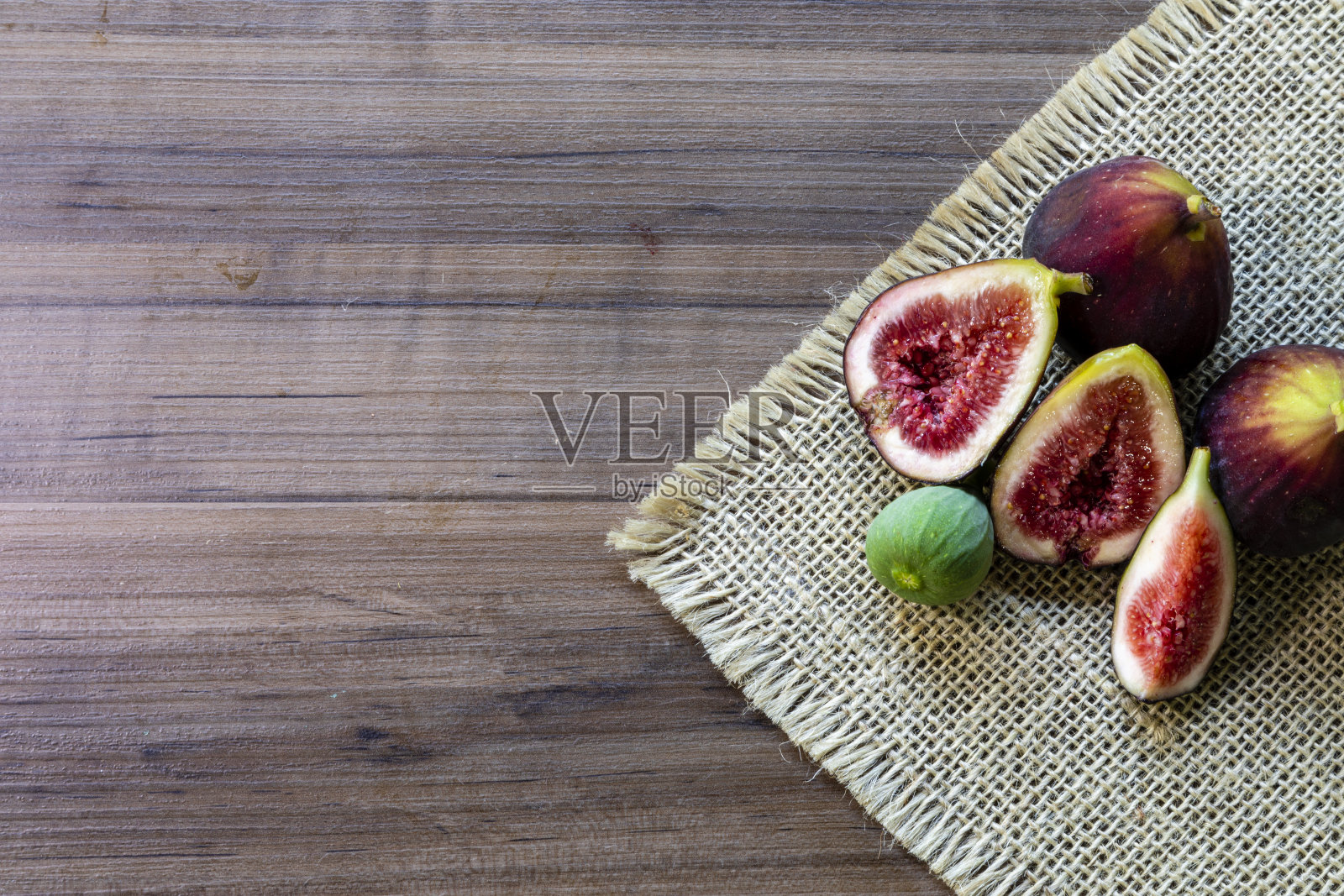 无花果的俯视图，绿色的叶子在乡村木制的背景。照片摄影图片