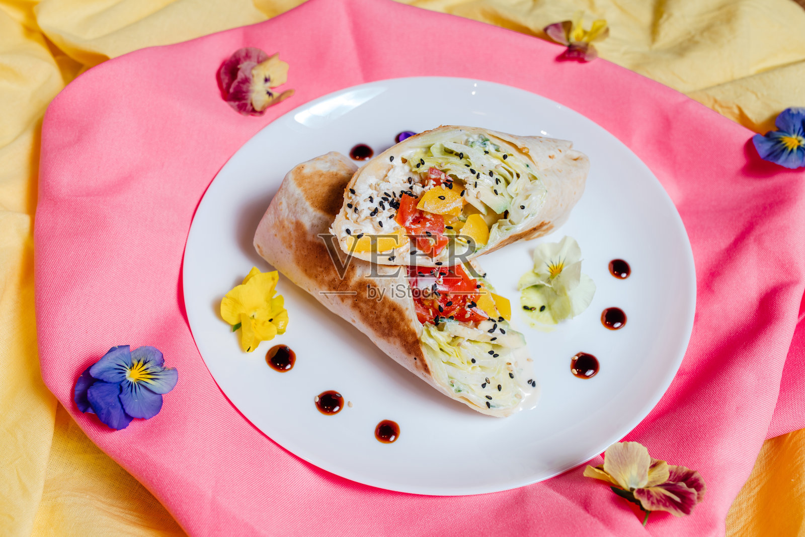 盘子里的素食玉米煎饼，旁边有花照片摄影图片