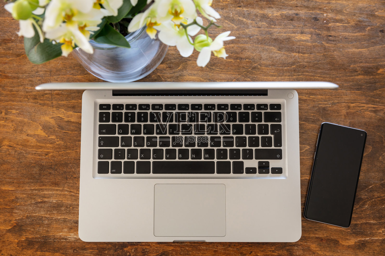 电脑、笔记本电脑和智能手机放在一张木质办公桌上，俯视图照片摄影图片