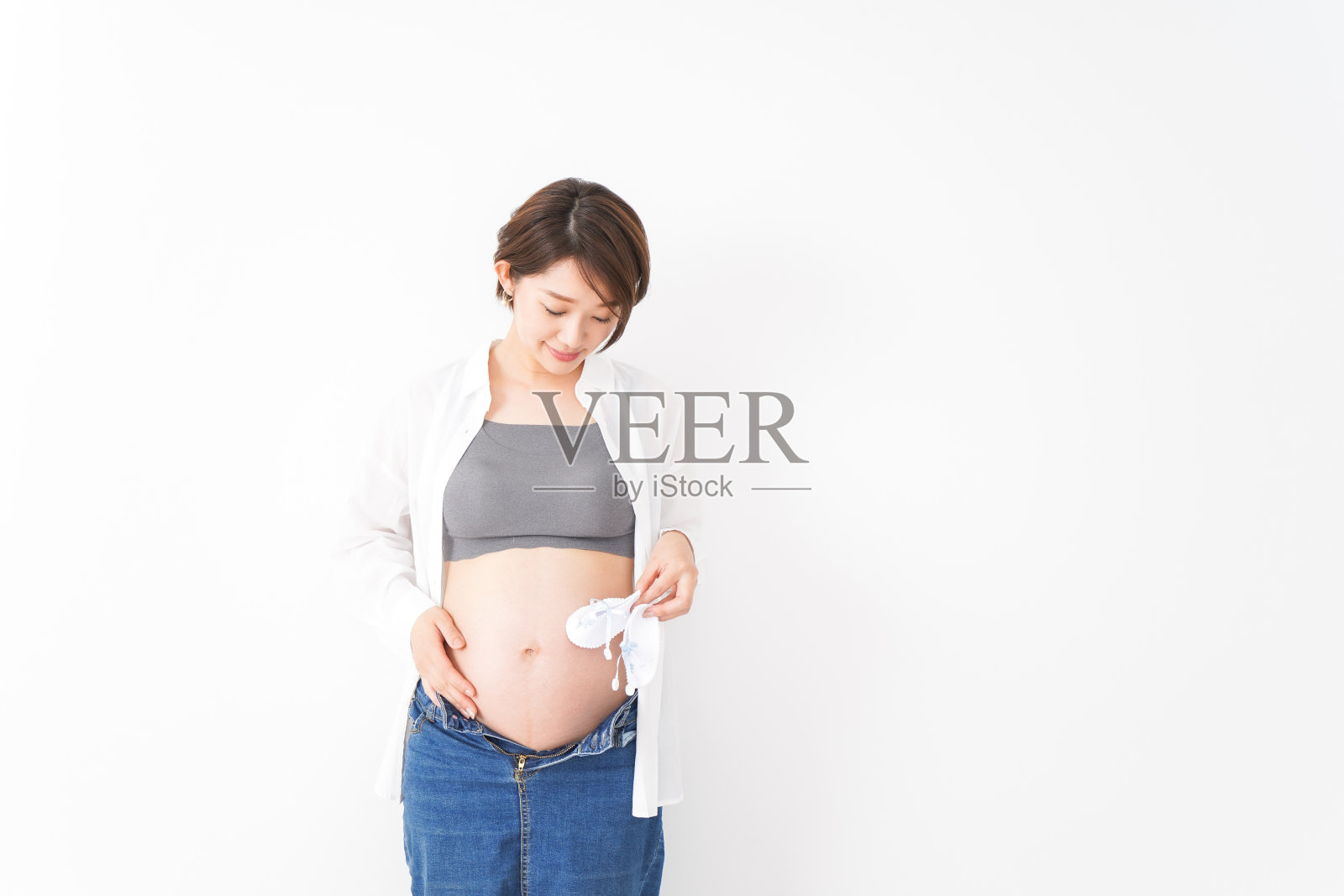 穿着休闲装微笑着的年轻孕妇照片摄影图片