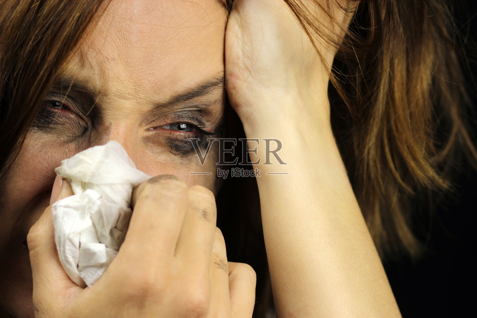 哭泣的女孩用手帕擤鼻子照片摄影图片
