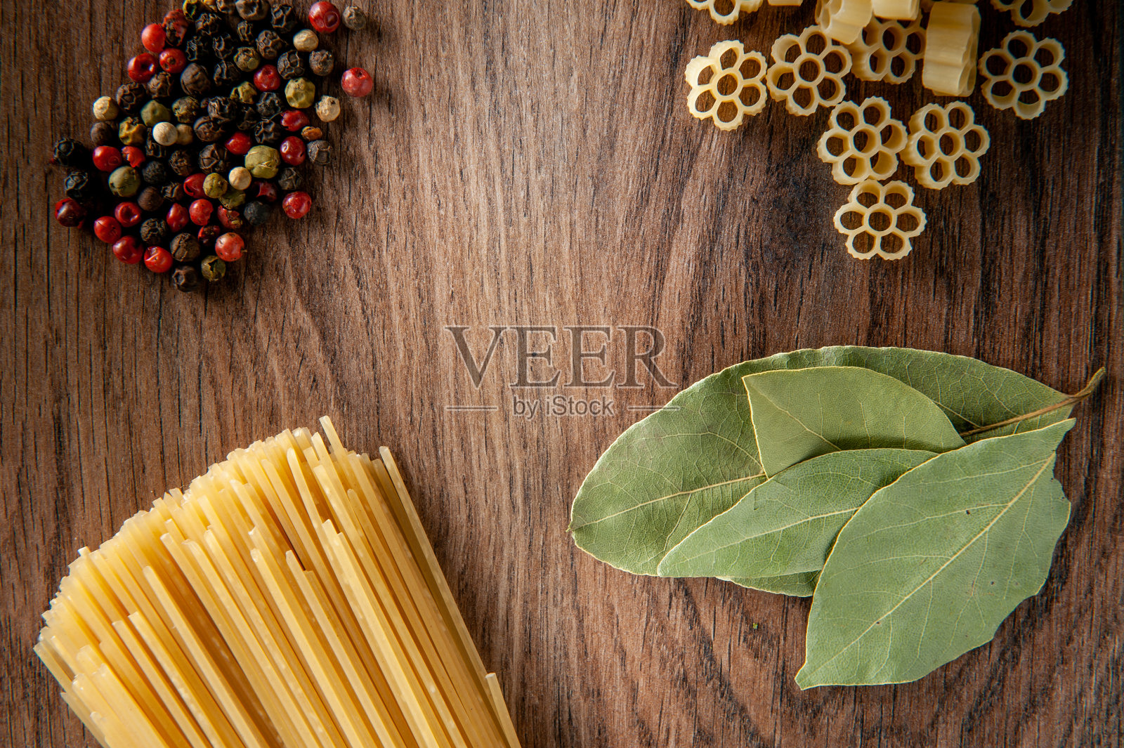 木桌上放着月桂叶和香料的意大利面，食物特写照片摄影图片