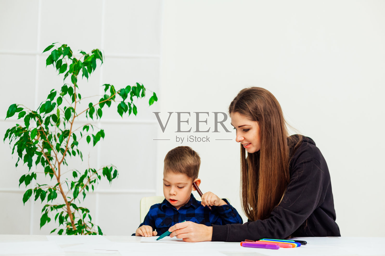 妈妈和小儿子在桌子上画画照片摄影图片