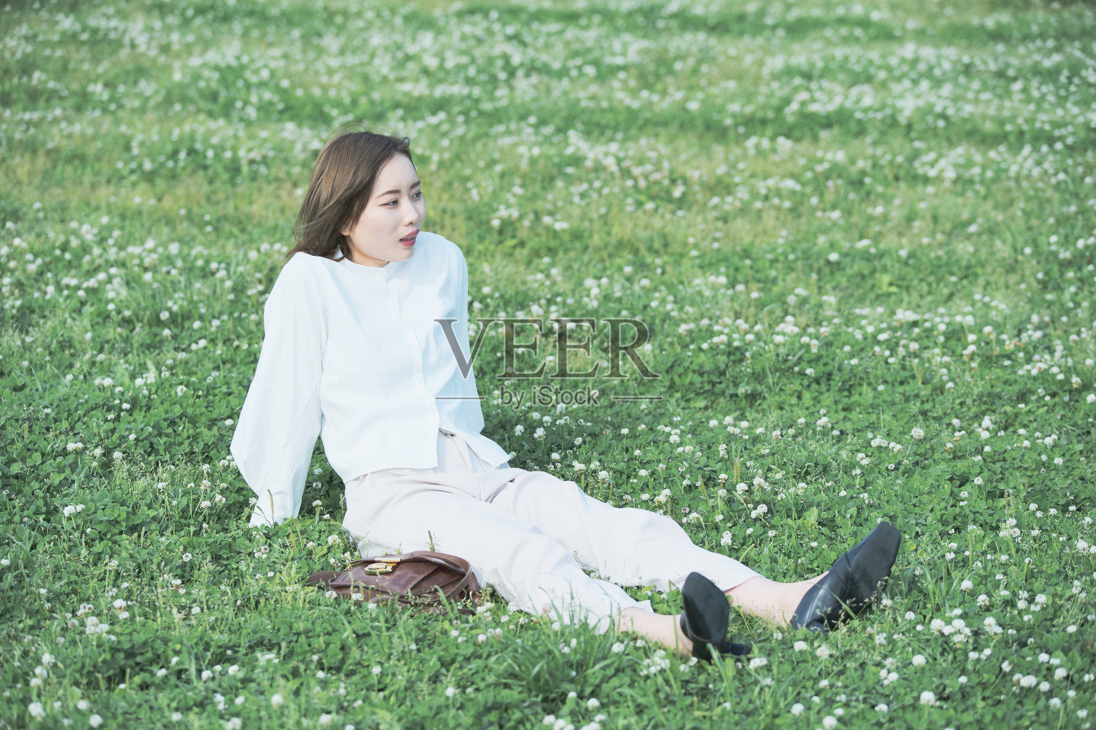 草地上的亚洲年轻女子照片摄影图片