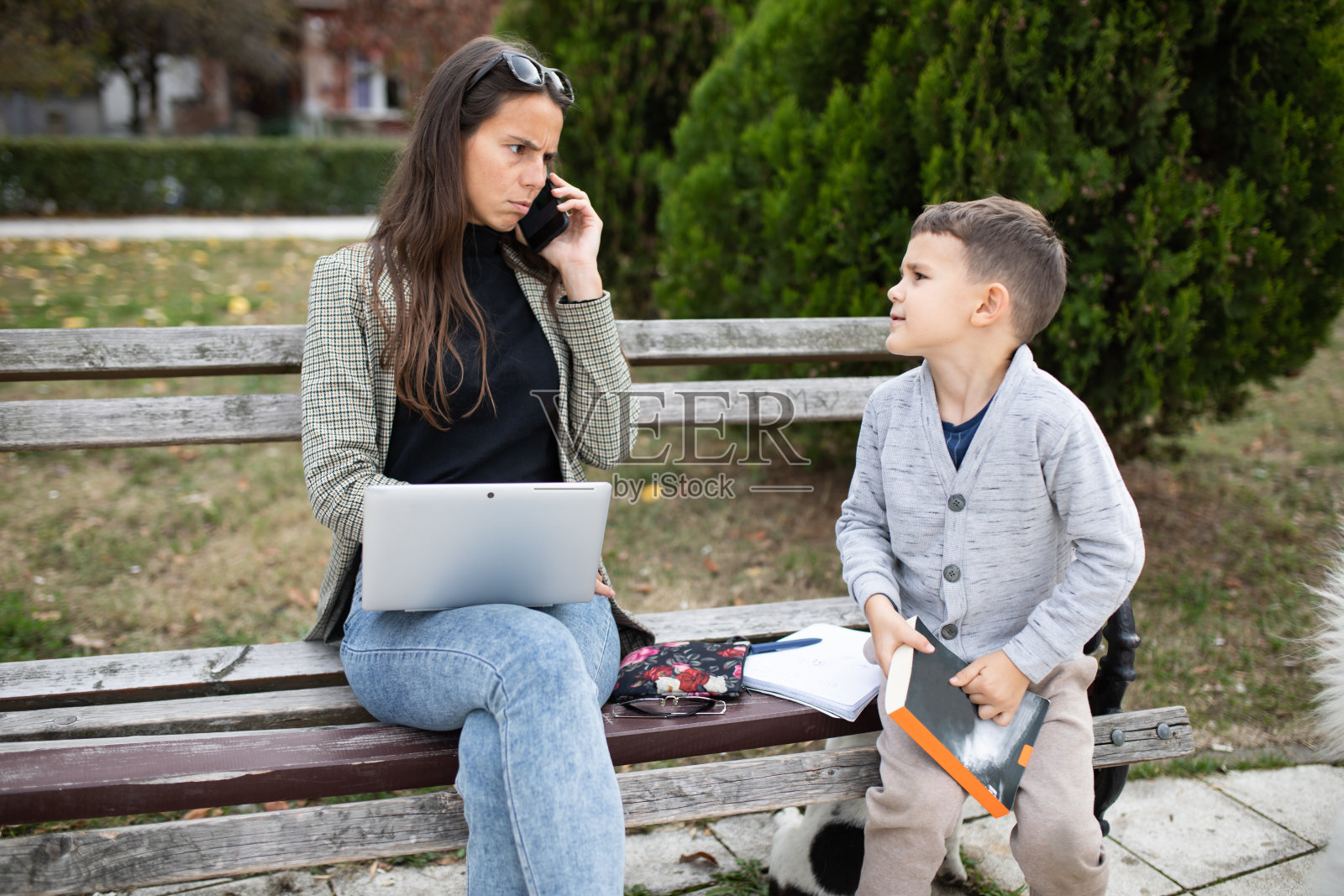 母亲因儿子在她打电话时打扰她而生气照片摄影图片